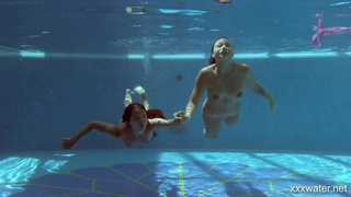 Две страстные нимфы купаются голышом в закрытом бассейне